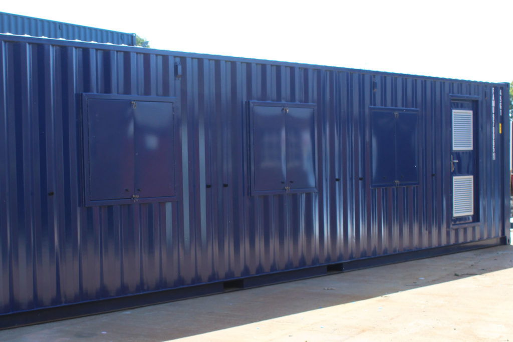 Exterior rear of converted container for motor sports including pedestrian door
