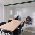 Interior of linked flat pack office with desks and meeting space